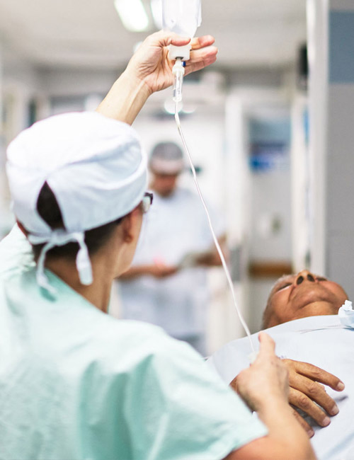 Doctor holding up a solution above a patient preparing for surgery